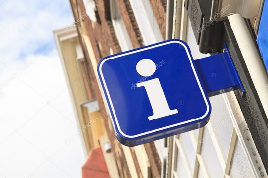 Staff member helping visitors choose attractions using brochures and maps